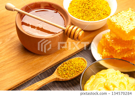 Delicious honey and bee products displayed on a wooden surface for culinary delight 134570284