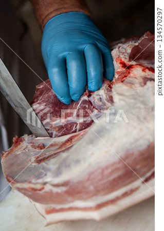 The hand of the professional butcher on the chopping block 134570297