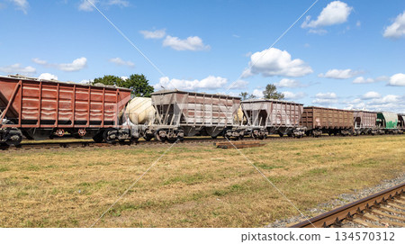 Freight cars on the tracks against a beautiful cloudy sky, railway infrastructure, transport, and industry Freight cars on the tracks against a beautiful cloudy sky, railway infrastructure, transport, and industry 134570312