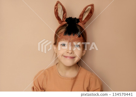 A surprised funny girl in a pony costume, dressed up for a festive Halloween masquerade.  The symbol of the new Year is the horse 2026 134570441