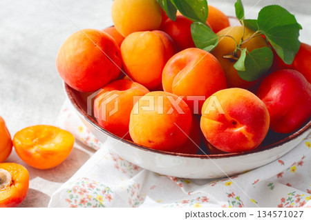 Fresh apricots in a bowl, on a bright table, natural light, top view, no people, 134571027