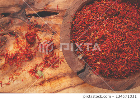 Spice saffron threads, in a wooden bowl, on a wooden table, top view, close-up, Spice saffron threads, in a wooden bowl, on a wooden table, top view, close-up, 134571031