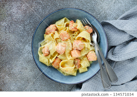papardelle pasta, in creamy sauce with salmon, homemade, on a gray background, no people, 134571034