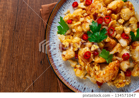 spicy fried cauliflower served on a wooden countertop, spicy fried cauliflower served on a wooden countertop, 134571047
