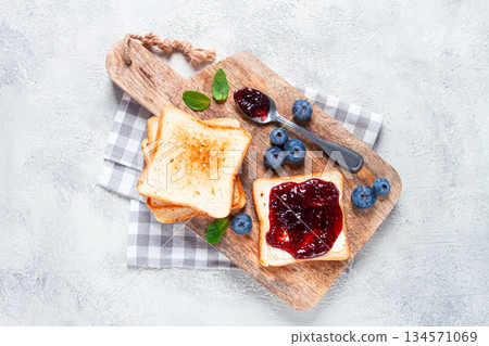 toast with blueberry jam, on a wooden chopping board, breakfast, homemade, no people, 134571069
