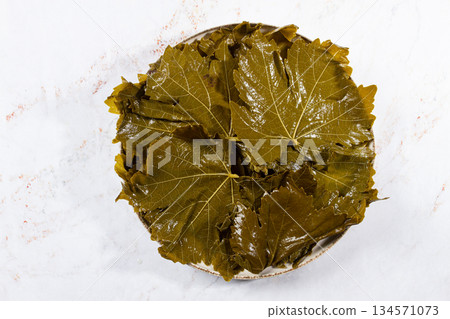canned grape leaves, for cooking dolma, on a plate, 134571073