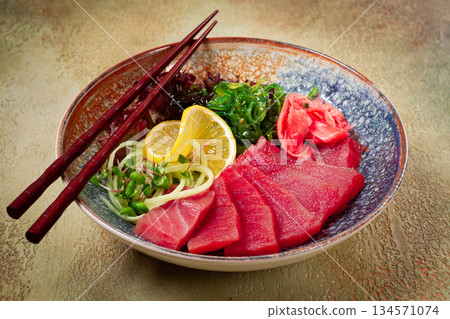 tuna sashimi with daikon and wakame salad, pickled ginger, in a bowl, 134571074