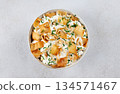 Levantine fatteh with pita chips, chickpeas, yogurt sauce, pine nuts and parsley on white background. Top view. 134571467