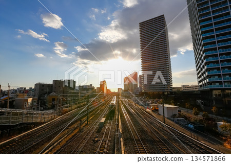 夕陽照亮了鐵軌和高層公寓。 134571866