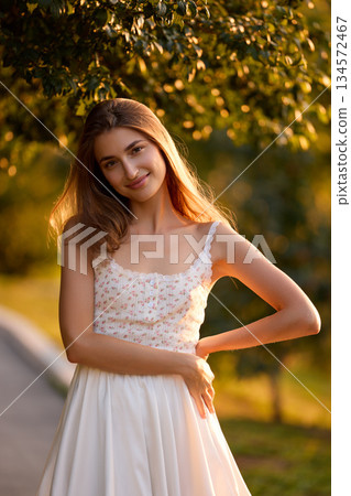 Slavic Woman in Sunlit Garden Wearing White Skirt Slavic Woman in Sunlit Garden Wearing White Skirt 134572467
