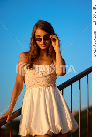 Slavic Woman in White Dress on Railing Slavic Woman in White Dress on Railing 134572499