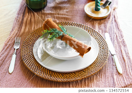 Festive Christmas aesthetic dinning setting with ceramic plates, linen napkin and natural decor 134572554