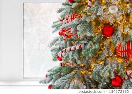 Christmas tree with frosted snowy branches decorated with red and white ornaments with lights Christmas tree with frosted snowy branches decorated with red and white ornaments with lights 134572585