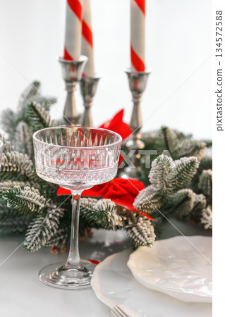 Elegant crystal tall glass with festive evergreen decor for Christmas holiday dinner Elegant crystal tall glass with festive evergreen decor for Christmas holiday dinner 134572588
