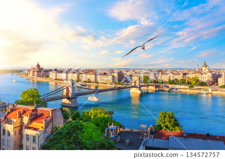 Chain Bridge and Parliament building in Budapest, Danube River at sunset with riverboats Chain Bridge and Parliament building in Budapest, Danube River at sunset with riverboats 134572757