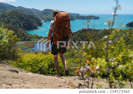Hiker wearing flip flops backpacking Abel Tasman Coast Track, New Zealand Hiker wearing flip flops backpacking Abel Tasman Coast Track, New Zealand 134573565