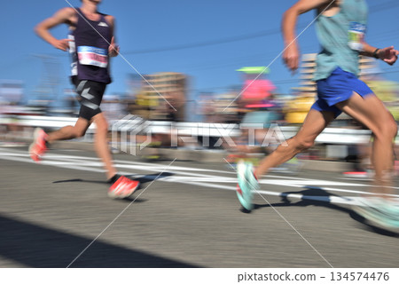 Marathon: Marathon runners running up a hill with slow shutter Marathon: Marathon runners running up a hill with slow shutter 134574476