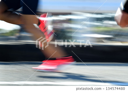 Marathon: Marathon runners running up a hill with slow shutter Marathon: Marathon runners running up a hill with slow shutter 134574480