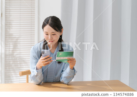 A woman looking at a passbook 134574886