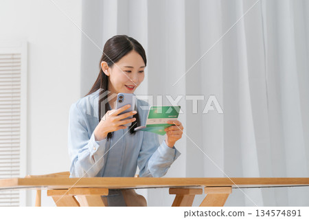 A woman looking at a passbook A woman looking at a passbook 134574891