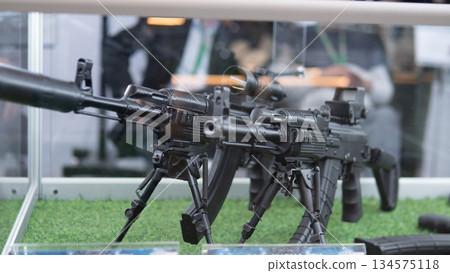 Display of firearms, Military rifle arrangement presented, Showcase of heavy guns with attachments and lighting, Exhibition of durable rifles on mounts with lighting and accessories Display of firearms, Military rifle arrangement presented, Showcase of heavy guns with attachments and lighting, Exhibition of durable rifles on mounts with lighting and accessories 134575118