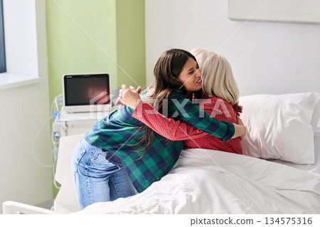 Emotional reunion between family members in a hospital room during a heartfelt visit 134575316