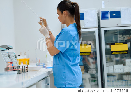 Medical professional prepares a sample in a clinical laboratory during work hours 134575336