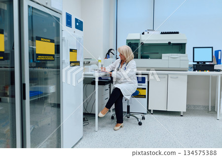Lab technician conducts analysis in modern research facility during daytime 134575388