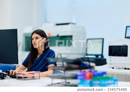 Medical professional works diligently in a modern laboratory setting during the day 134575490
