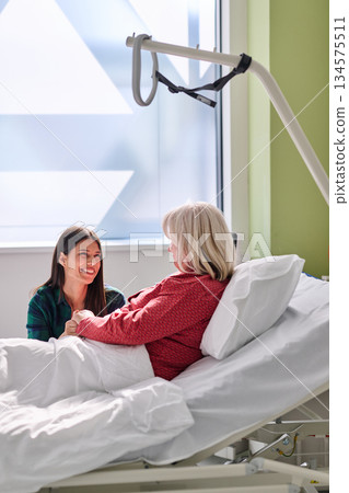 Warm reunion between a caregiver and patient inside a bright hospital room during a peaceful afternoon visit Warm reunion between a caregiver and patient inside a bright hospital room during a peaceful afternoon visit 134575511