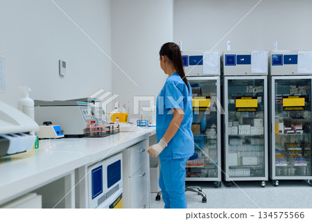 Medical professional working in a laboratory setting organizing samples and equipment for testing during the afternoon shift Medical professional working in a laboratory setting organizing samples and equipment for testing during the afternoon shift 134575566