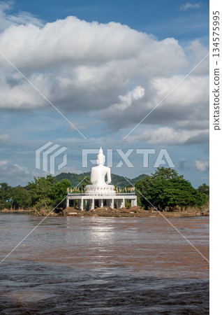 The white Buddha statue situated on the island in Mae Kok river in Chiang Rai province of Thailand. This river is the blood line for people of Chiang Rai, started from the hills on boarder of Myanmar. The white Buddha statue situated on the island in Mae Kok river in Chiang Rai province of Thailand. This river is the blood line for people of Chiang Rai, started from the hills on boarder of Myanmar. 134575995