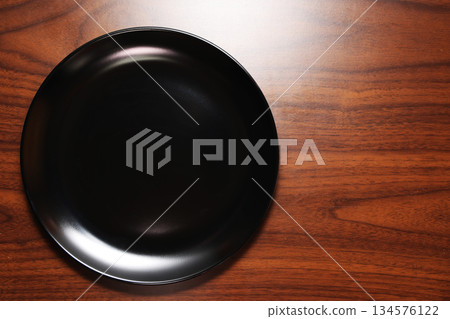 Black plates on the dining table Black plates on the dining table 134576122