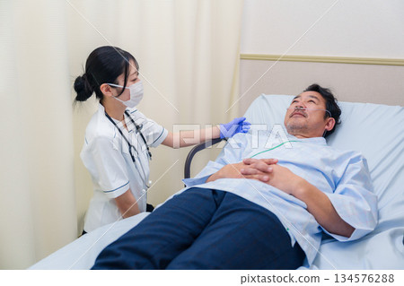 一位在病房照顧住院病人的女醫護人員 134576288