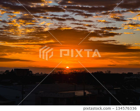 Orange clouds and sunrise over a residential area 134576336