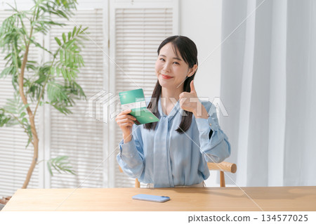 A woman looking at a passbook and smiling A woman looking at a passbook and smiling 134577025