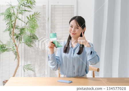A woman looking at a passbook and smiling A woman looking at a passbook and smiling 134577028