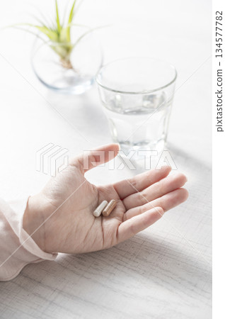女人的手拿著補充劑 女人的手拿著補充劑 134577782