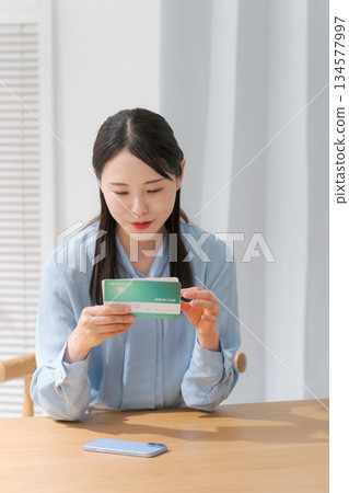 A woman looking at a passbook 134577997