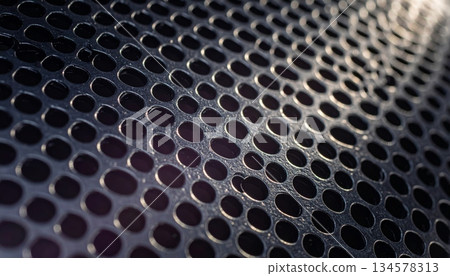 Industrial dark steel metallic mesh background featuring a perforated black iron grid pattern with a chrome textured surface for a modern gray carbon grill design Industrial dark steel metallic mesh background featuring a perforated black iron grid pattern with a chrome textured surface for a modern gray carbon grill design 134578313