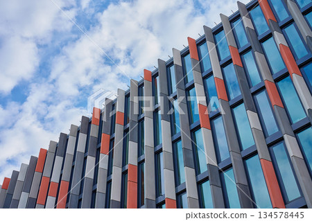 Modern geometric facade of multicolored urban building with glass windows Modern geometric facade of multicolored urban building with glass windows 134578445