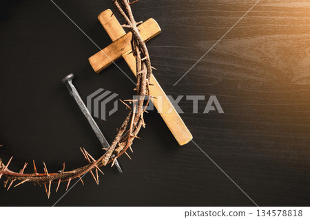 Crown of thorns, wooden cross, iron nail placed on Holy Bible, symbolizing Christian faith, sacrifice, crucifixion, Easter reflection, religion background for worship, spiritual concept Crown of thorns, wooden cross, iron nail placed on Holy Bible, symbolizing Christian faith, sacrifice, crucifixion, Easter reflection, religion background for worship, spiritual concept 134578818
