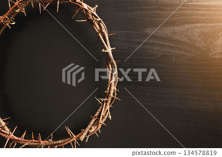 Crown of thorns, wooden cross, iron nail placed on Holy Bible, symbolizing Christian faith, sacrifice, crucifixion, Easter reflection, religion background for worship, spiritual concept 134578819