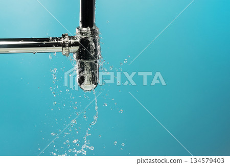 Water leak under sink on Nut Bolt stainless steel. Drain sink leak water from pipe plumbing in bathroom and repair by flume wrench tools as water splash drop. Blue background isolated Water leak under sink on Nut Bolt stainless steel. Drain sink leak water from pipe plumbing in bathroom and repair by flume wrench tools as water splash drop. Blue background isolated 134579403