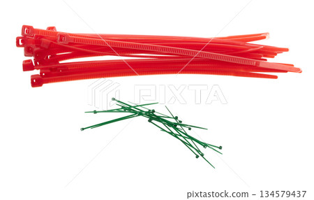 Plastic Cable tie in red to hold cable together or wrap around things for electrician, maintenance, repair man. Close up Plastic Cable tie small size, white background isolated 134579437