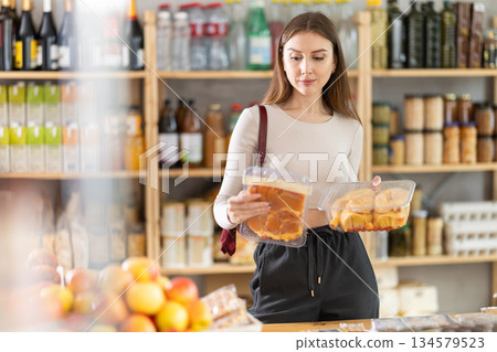 Young woman choosing chicken in grocery store Young woman choosing chicken in grocery store 134579523