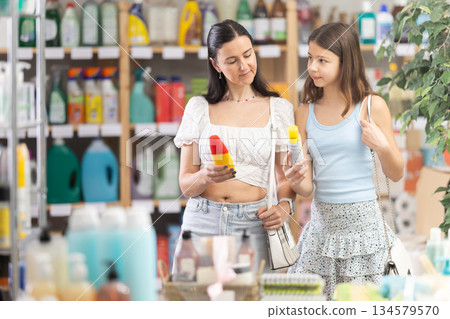 Mom with teen girl view trademark sign on label, pick eco friendly mosquito repellent Mom with teen girl view trademark sign on label, pick eco friendly mosquito repellent 134579570