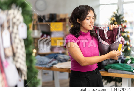 Asian woman choosing a bra on the background of the Christmas tree Asian woman choosing a bra on the background of the Christmas tree 134579705