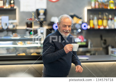 Elderly man drinking coffee in cafe Elderly man drinking coffee in cafe 134579718