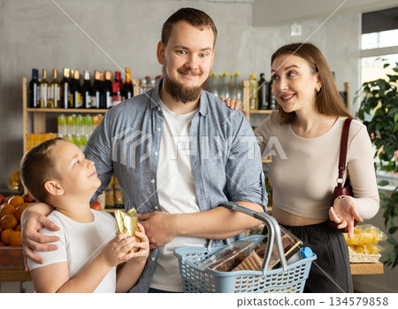 Man with wife and son shopping in grocery store Man with wife and son shopping in grocery store 134579858